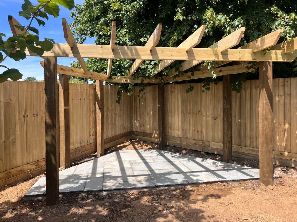 Timber pergola over a sandstone paved corner, built by PC Landscaping in a South Devon garden
